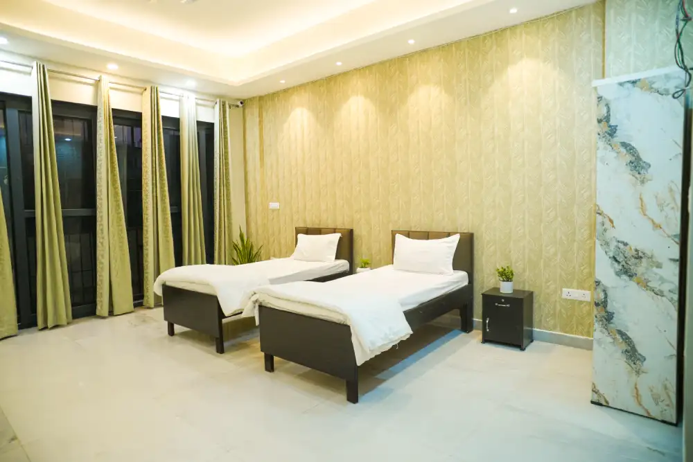 Twin-bed room with curtains and a side table at Panaah Rehabilitation Centre