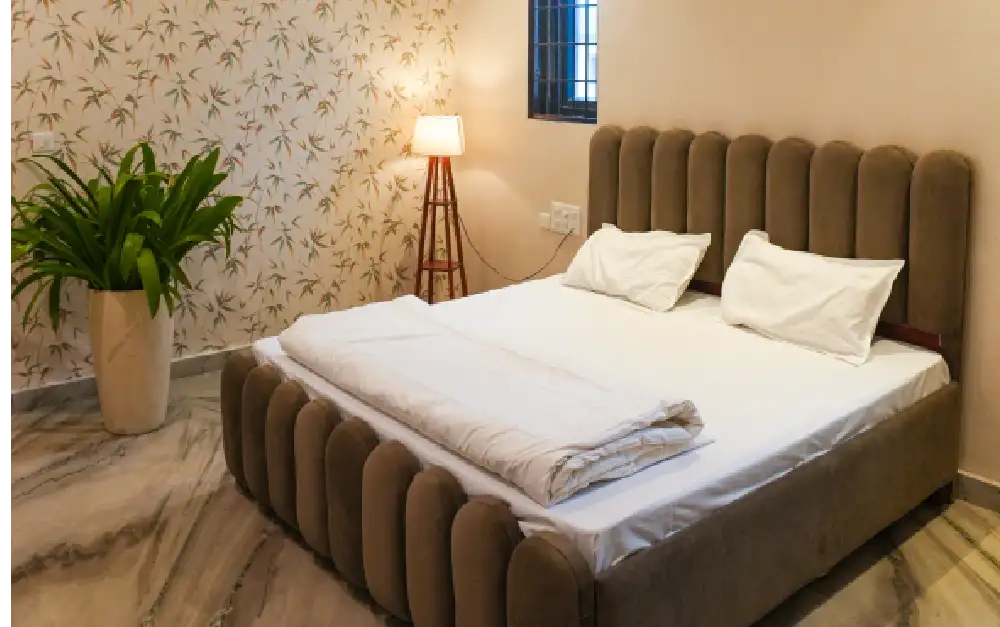 Double bedroom with a cushioned bed and bedside lamp at Panaah Rehabilitation Centre